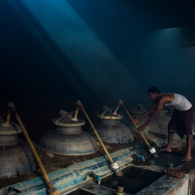 A worker fixes the Chonga (bamboo pipe) to the Deg (distillation pot). The fumes (Bhap) pass through the Chonga and condense in small pots called Bhapkas (Courtesy: Udit Kulshreshtra)