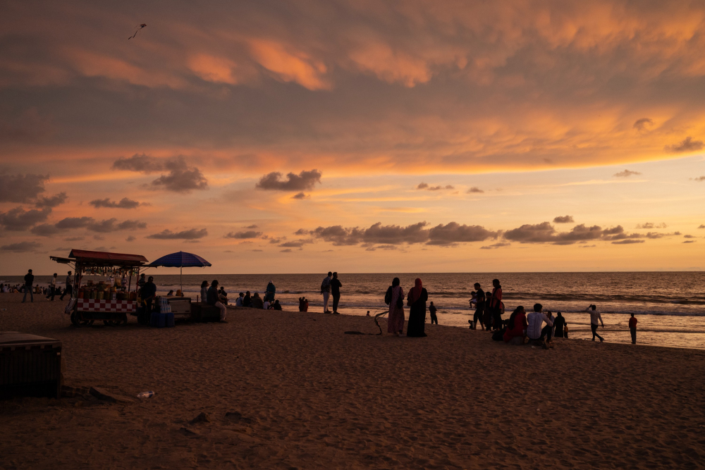 People gather to enjoy the sunset at Kozhikode beach.