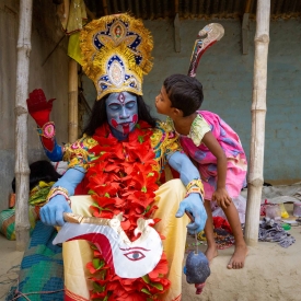 Basudeb Chowdhury Byadh, fully dressed in the character of goddess Kali, has a private moment with his 5-year-old daughter Bithi.