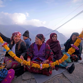 Women of the Gurung household weave together a garland for the departed soul; it is considered an offering that they might need in their journey to the afterlife. Hence, unlike regular floral garlands, these contain food items such as biscuits and snacks (Courtesy: Priyanka Chharia)