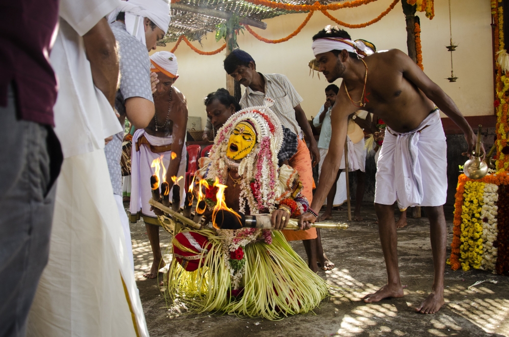 Fig. 1: Bhootakola at Orvadi Guttu, Hiriyadka. The paatri is seen paying his respects to the owner of the Orvadi Guttu. Every bhootakola event begins with this tradition where the paatri first pays respects to the guttu owner before the proceedings 